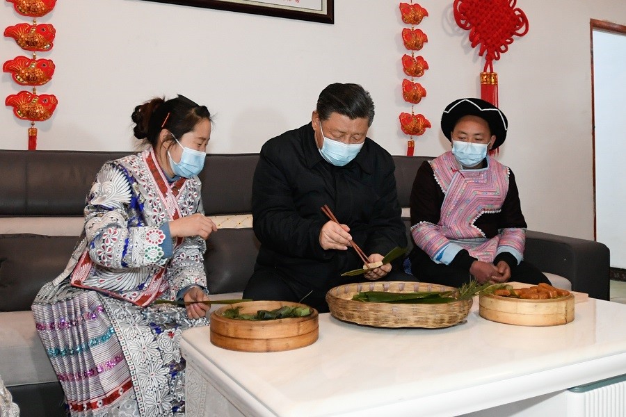 2021年2月3日下午，習(xí)近平在貴州畢節(jié)市黔西縣新仁苗族鄉(xiāng)化屋村苗族村民趙玉學(xué)家，同一家人邊聊家常邊制作當(dāng)?shù)貍鹘y(tǒng)節(jié)日食品黃粑。新華社記者 李學(xué)仁 攝